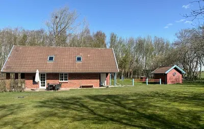 a red brick house in a field next to a yard at Nice Home In Roslev With Wifi in Roslev