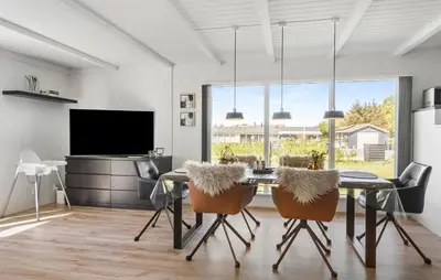a dining room with a table and chairs and a television at 3 Bedroom Cozy Home In Vinderup in Vinderup