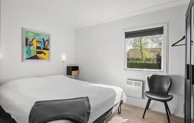 a bedroom with a bed and a chair and a window at 3 Bedroom Cozy Home In Vinderup in Vinderup