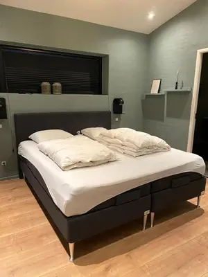 a bedroom with a large bed with white sheets at Moderne bynært hus in Holstebro