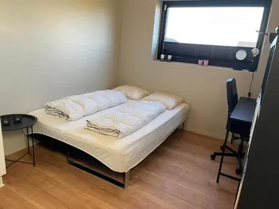 a small bed in a room with a window at Moderne bynært hus in Holstebro