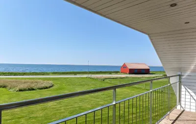 a view of a red barn from the balcony of a house at Awesome Home In Vestervig With Sauna in Vestervig