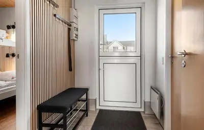 a door with a bench and a window in a room at Awesome Home In Vestervig With Sauna in Vestervig