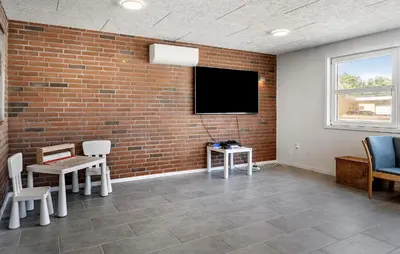 a room with a brick wall and a flat screen tv at Awesome Home In Vestervig With Sauna in Vestervig