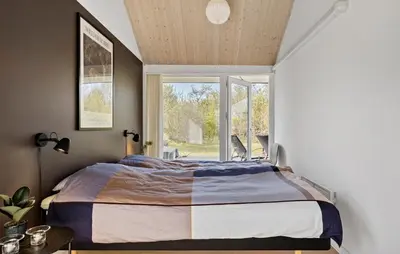 a bedroom with a large bed and a window at Gorgeous Home In Brovst With Sauna in Brovst