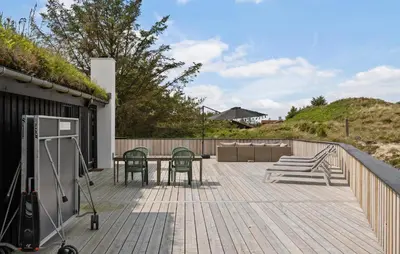 a patio with a table and chairs on a deck at 4 Bedroom Cozy Home In Saltum in Saltum
