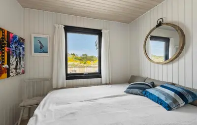 a bedroom with a bed with a mirror and a window at 4 Bedroom Cozy Home In Saltum in Saltum