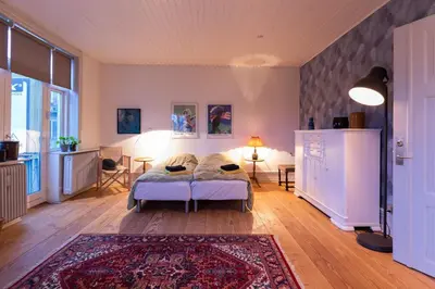 a bedroom with a bed and a rug at Lejlighed i Holstebro gågade in Holstebro