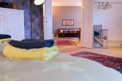 a bedroom with a bed and a living room at Lejlighed i Holstebro gågade in Holstebro