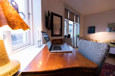 a laptop computer sitting on a wooden desk in a living room at Lejlighed i Holstebro gågade in Holstebro