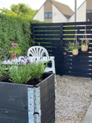 a garden with a white chair and some plants at Cozy big apartment in Blokhus