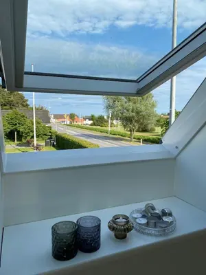 a kitchen counter with a large window in a room at Cozy big apartment in Blokhus