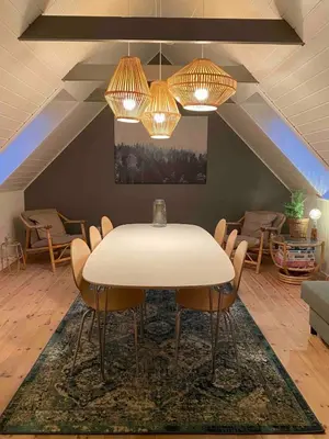 a dining room with a white table and chairs at Cozy big apartment in Blokhus