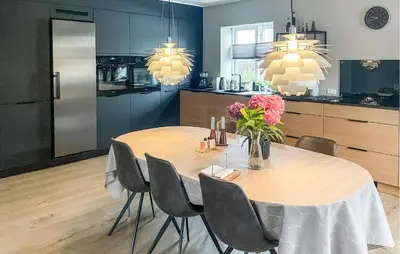 a kitchen and dining room with a table and chairs at Cozy Home In Thyborøn With Wifi in Thyborøn