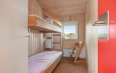 a small bedroom with a bunk bed and a window at Stunning Home In Blokhus With Wifi in Blokhus
