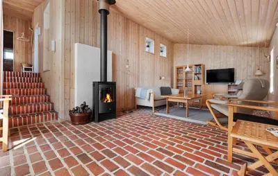 a living room with a fireplace and a television at Stunning Home In Blokhus With Wifi in Blokhus