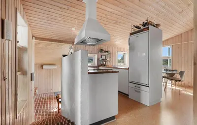 a kitchen with a white refrigerator and a table at Stunning Home In Blokhus With Wifi in Blokhus