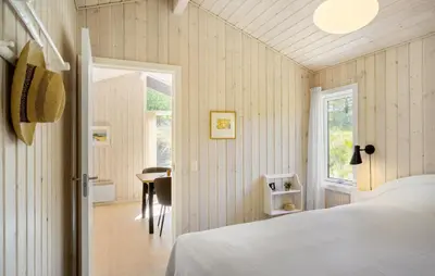 a bedroom with a white bed and a table at 3 Bedroom Beautiful Home In Blokhus in Blokhus
