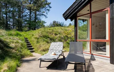 a couple of chairs and a table on a patio at 3 Bedroom Beautiful Home In Blokhus in Blokhus
