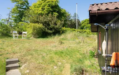 two chairs in a field next to a house at 3 Bedroom Beautiful Home In Blokhus in Blokhus