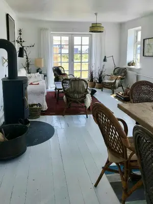 a living room with a wood stove and chairs at Charmerende Villa Havly Nær Vesterhavet in Harboør