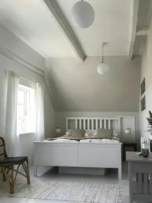 a white bedroom with a large white bed in a room at Charmerende Villa Havly Nær Vesterhavet in Harboør