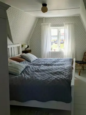 a bedroom with a bed and a window at Charmerende Villa Havly Nær Vesterhavet in Harboør