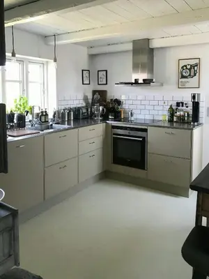 a kitchen with white cabinets and a stove top oven at Charmerende Villa Havly Nær Vesterhavet in Harboør