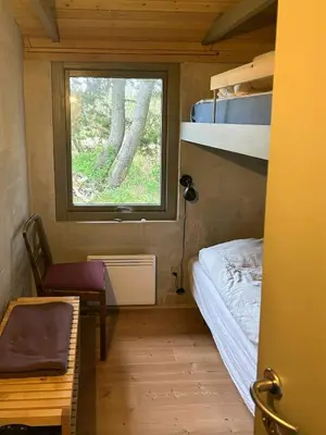 a small bedroom with a bunk bed and a window at Summer House With Fields And Fjord Views in Thyholm