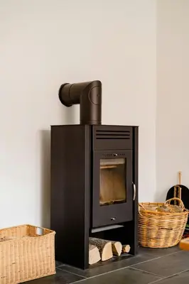 a black stove in a room with a basket at Lovely House Near Nature For Relaxation in Fjerritslev