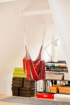 a hammock hanging from the ceiling in a room with books at Lovely House Near Nature For Relaxation in Fjerritslev