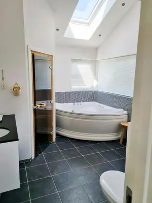 a bathroom with a large tub and a toilet at Modern House Close To The North Sea in Tranum