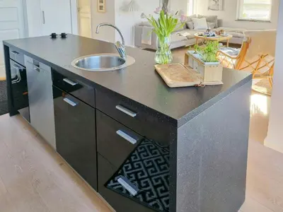 a kitchen with a counter with a sink in it at Modern House Close To The North Sea in Tranum