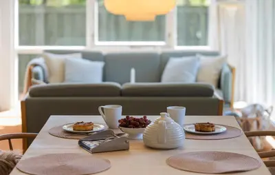 a table with two plates of food and a couch at 3 Bedroom Stunning Home In Blokhus in Blokhus