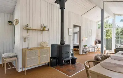 a living room with a wood stove in it at 3 Bedroom Stunning Home In Blokhus in Blokhus
