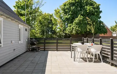 a patio with a table and chairs next to a fence at Stunning Home In Vemb With Wifi in Vemb