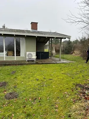 a house with a porch with a microwave on it at Hygge in the North Sea Cabin in Fjerritslev