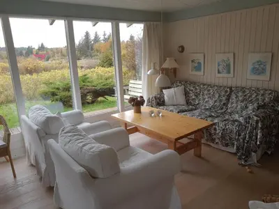 a living room with a couch and a table at Hygge in the North Sea Cabin in Fjerritslev