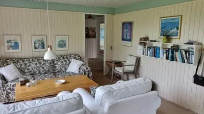 a living room with a couch and a table at Hygge in the North Sea Cabin in Fjerritslev