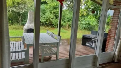 a screened in porch with a picnic table and a grill at Hygge in the North Sea Cabin in Fjerritslev