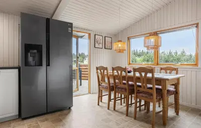 a dining room with a table and a refrigerator at 3 Bedroom Beautiful Home In Thisted in Thisted