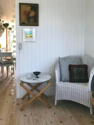 a living room with a table and a chair at Cozy Wagon House With Views Over The Limfjord in Roslev