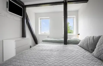 a bedroom with a bed and a tv and two windows at Gorgeous Home In Hurup Thy With Wifi in Sønder Ydby