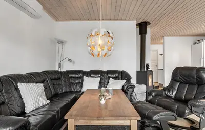 a living room with a leather couch and a table at 3 Bedroom Cozy Home In Højslev in Højslev