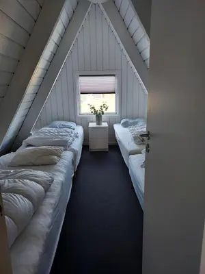 a attic room with three beds and a window at Holiday home golf house in beautiful Himmerland Farsø in Farsø