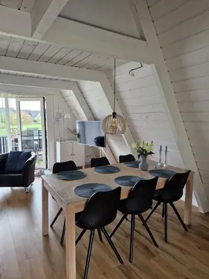 a dining room with a wooden table and chairs at Holiday home golf house in beautiful Himmerland Farsø in Farsø