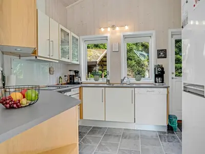 a kitchen with white cabinets and a bowl of fruit on the counter at Holiday Home Atti - 500m to the fjord by Interhome in Højslev