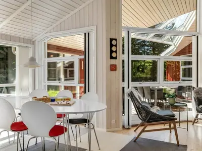 a dining room with a white table and chairs at Holiday Home Atti - 500m to the fjord by Interhome in Højslev