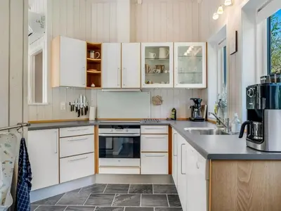 a kitchen with white cabinets and a sink at Holiday Home Atti - 500m to the fjord by Interhome in Højslev