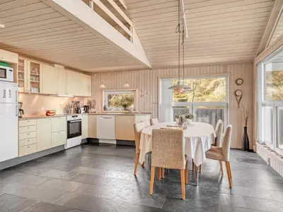 a kitchen with a table and chairs in a room at Holiday Home Elni - 350m from the sea by Interhome in Blokhus